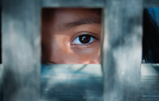 a person locked in a building looking outside showing contemporary slavery