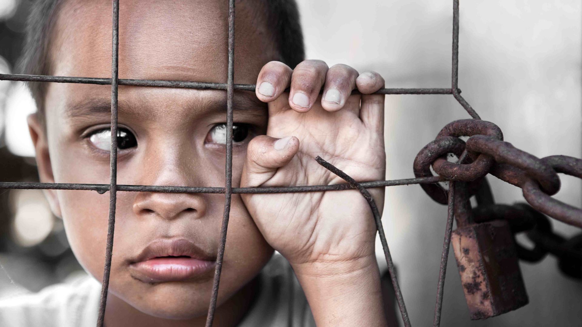 a small girl looking sad locked inside showing human trafficking