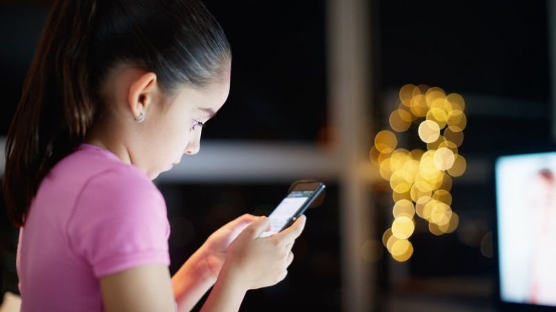 a small girl using a phone showing how Tech Fuels Child Trafficking